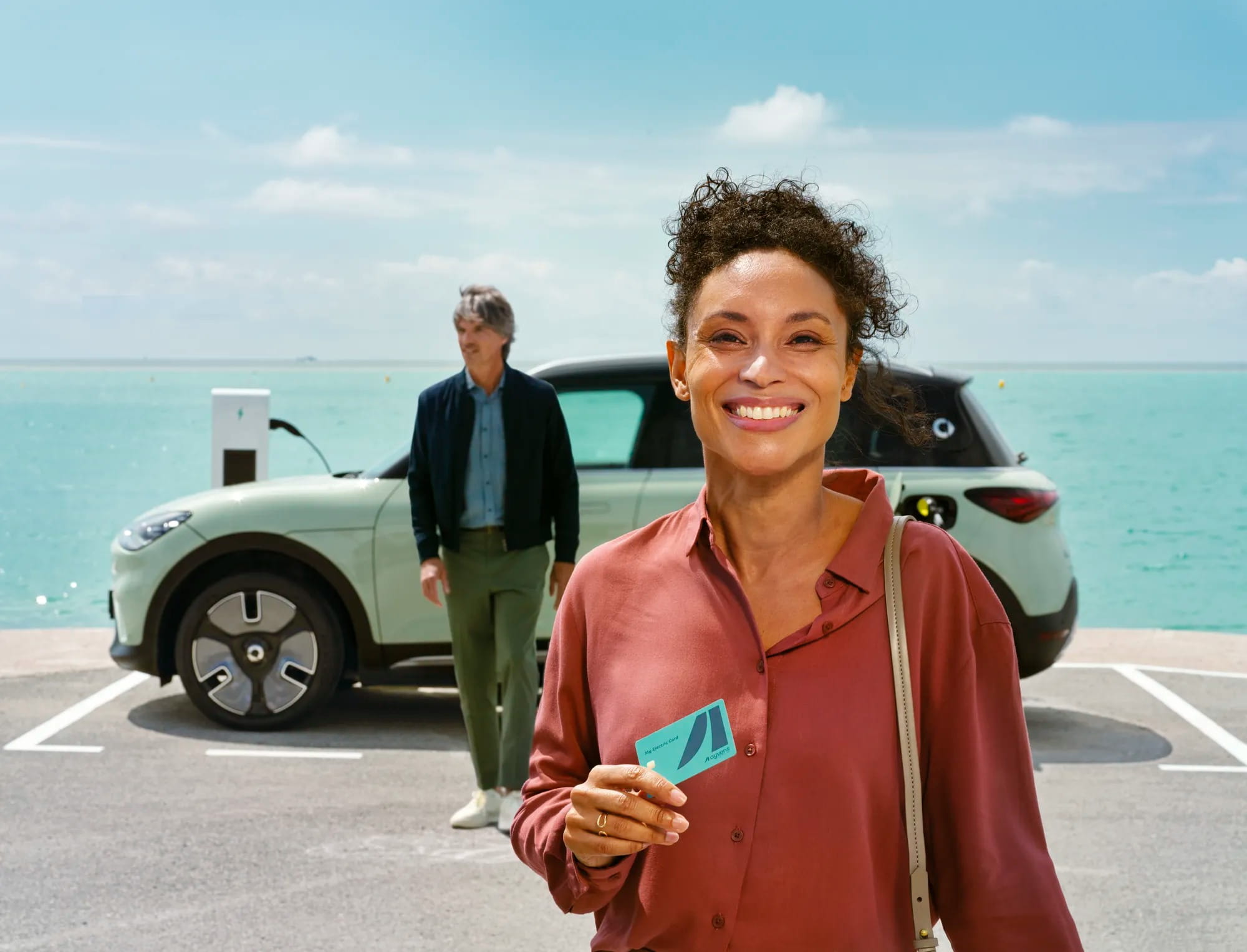 Woman smiling holding Ayvens card