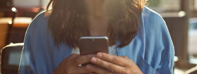 Mulher a segurar o telemóvel