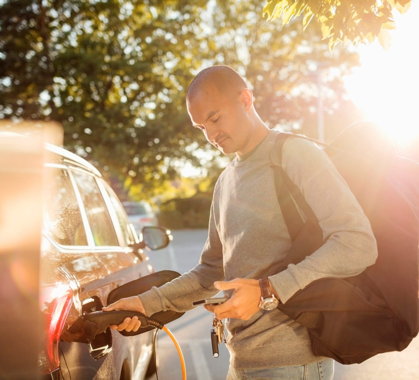 man charging car and looking into the phone
