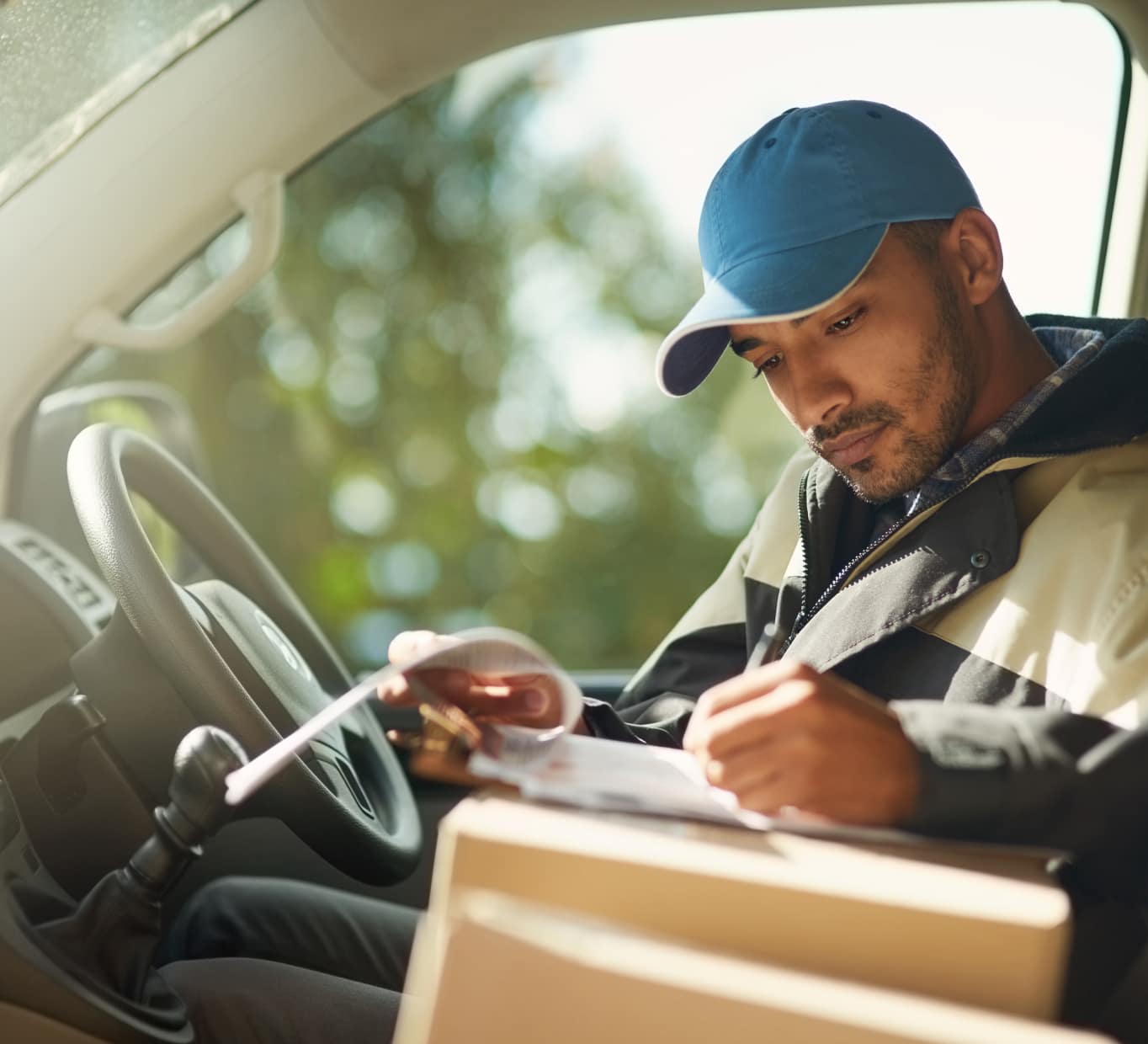 Man writing in a box inside a car