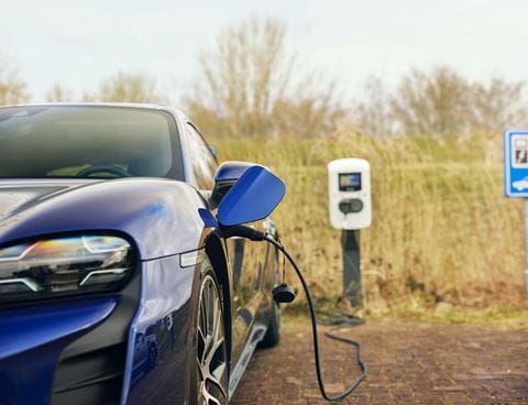 Blue car charging in public
