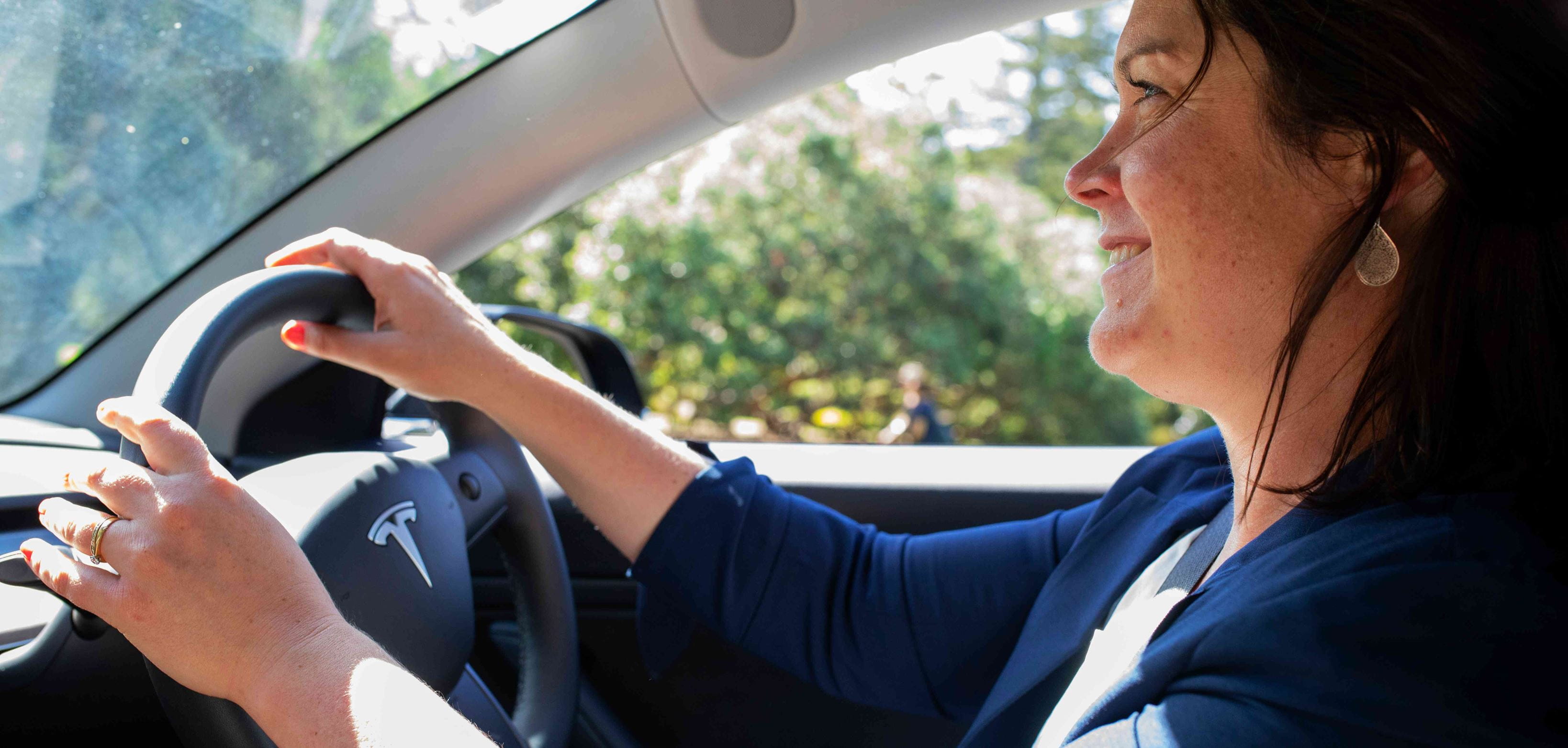 Close up - a woman driving a Tesla