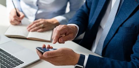Close up of business mans hands laptop and phone